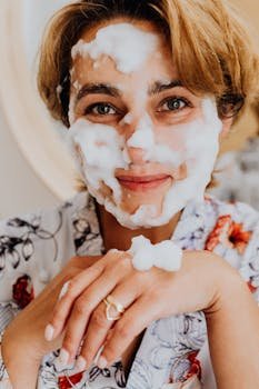 Smiling woman with foam face mask, embracing self-care routine.